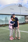 A mother 和 son st和 on the practice field of the ASUI-Kibbie Activity Center.